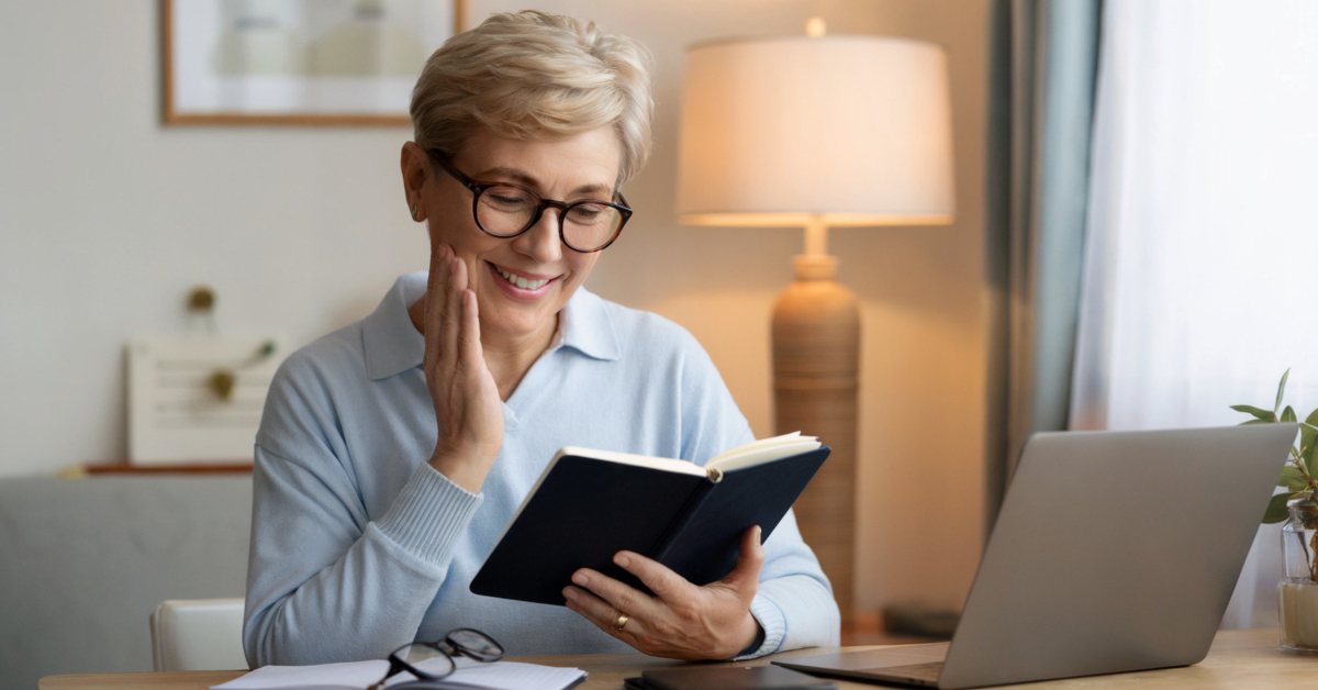 A retired person smiling while reviewing notes or a tablet, representing clear answers to common digital product questions.