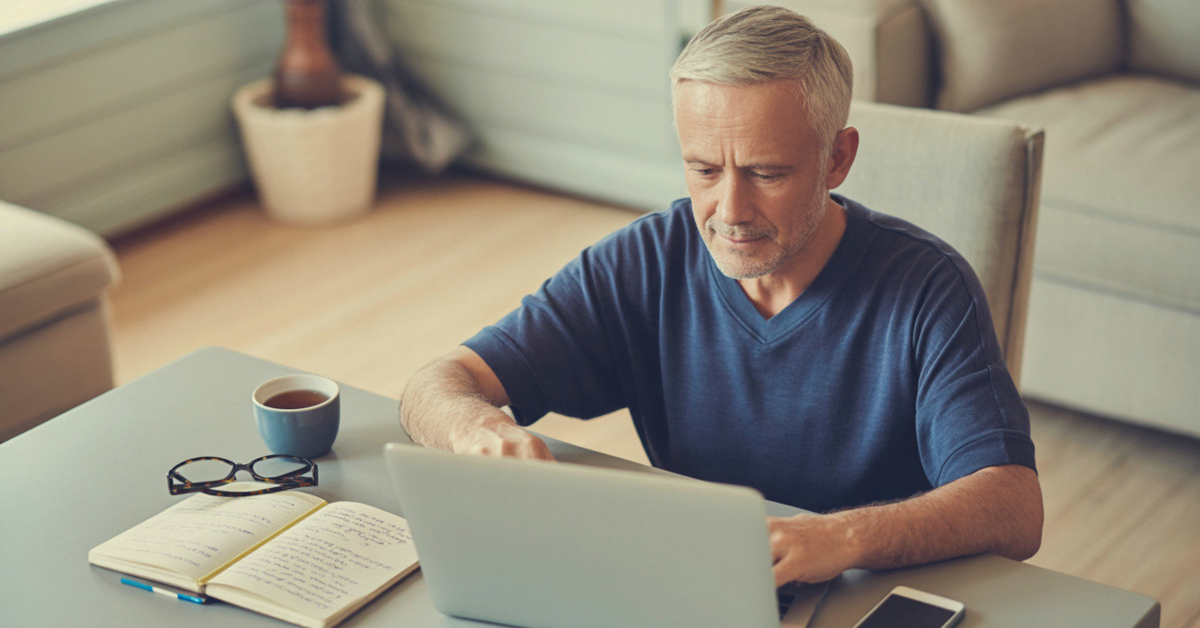 A male retiree using simple technology at home, showing the basic skills, time, and tech needed to start earning online
